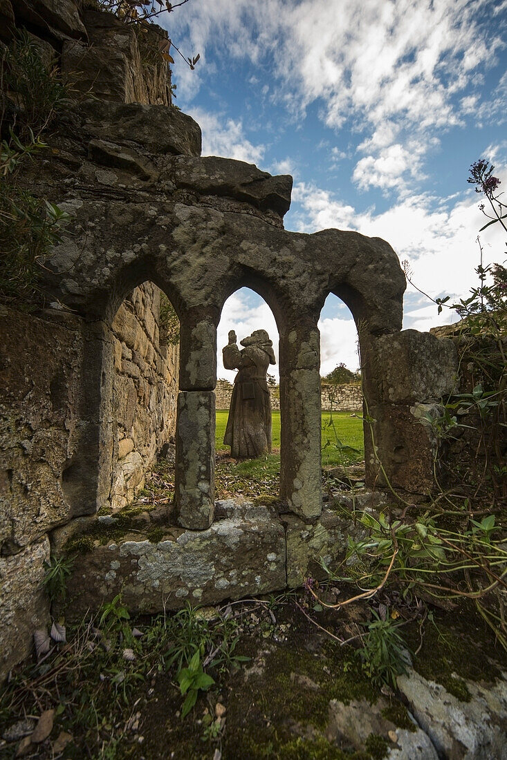 Hume Park, Statue seen through arched window of ruined building; Alnwick, Northumberland, England, UK