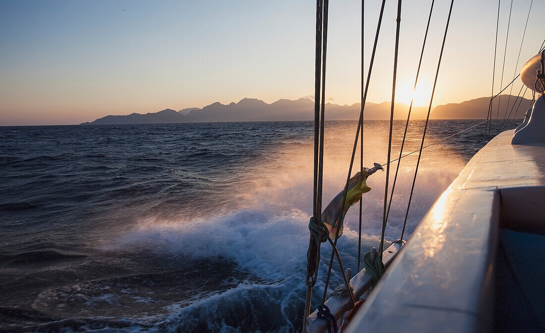 Boot plätschert durch Wasser entlang der lykischen Küste bei Sonnenuntergang; Türkei