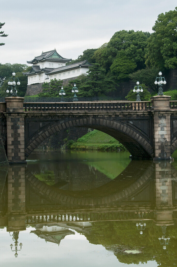 Bridge crossing river reflected in tranquil water; Tokyo, Japan