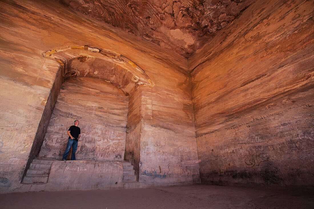 Jordanien, es ist 50 Meter breit und etwa 45 Meter hoch; Petra, Mann betrachtet Ad Deir (arabisch für Das Kloster) ist ein monumentales, aus dem Fels gehauenes Gebäude in der antiken Stadt Petra. Erbaut von den Nabatäern im 1.
