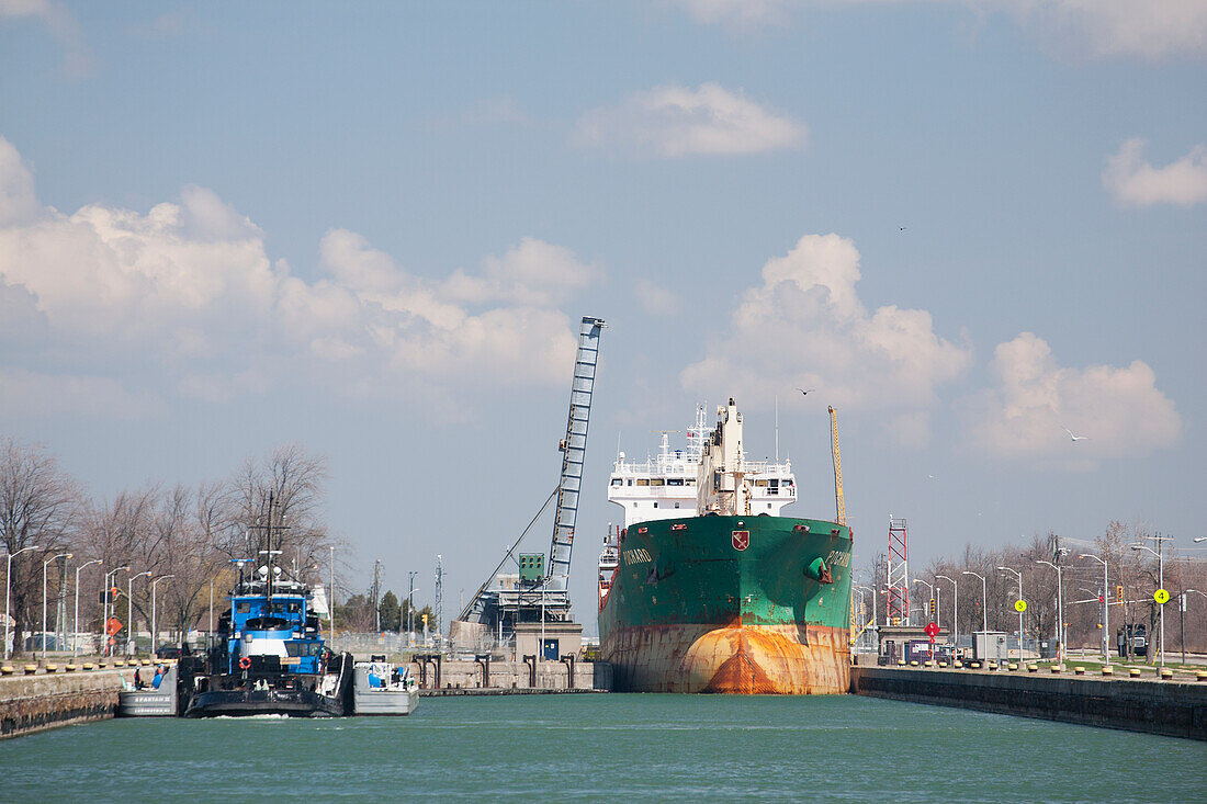 Large Ship In Welland Canal, Bridge Raised With Clouds And Blue Sky; Port Colborne, Ontario, Canada