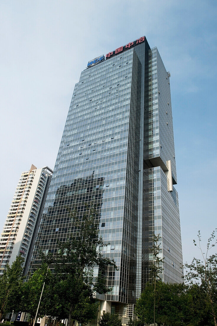 Ein Wolkenkratzer, der ein anderes Gebäude in der Glaswand reflektiert; Peking, China