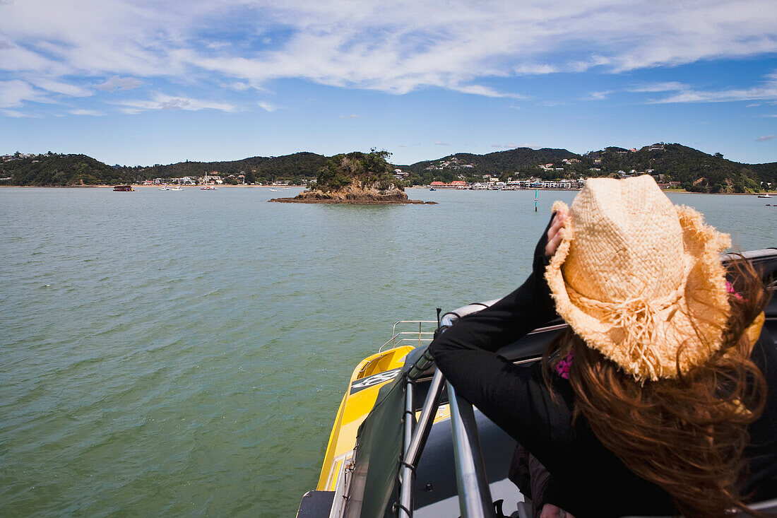 Ein Mädchen hält ihren Cowboyhut auf einer Bootsfahrt von Russell nach Paihia; Neuseeland