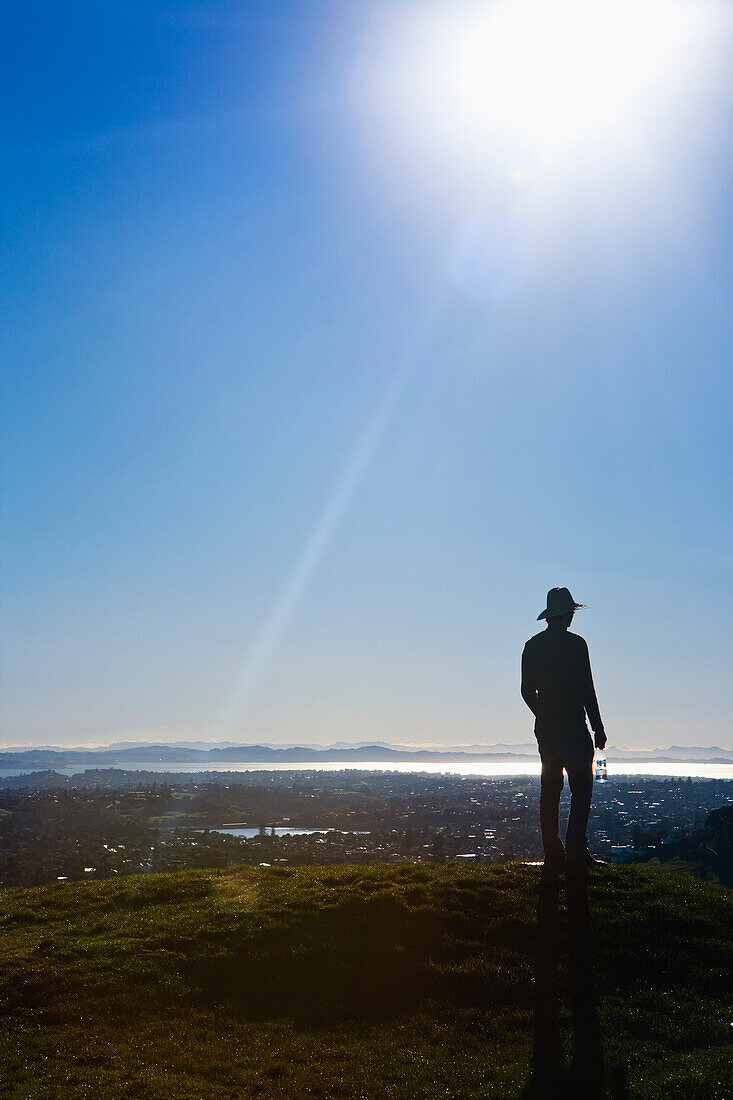 Silhouette eines Mannes mit Hut auf dem Mt. Eden mit Blick auf Auckland; Neuseeland