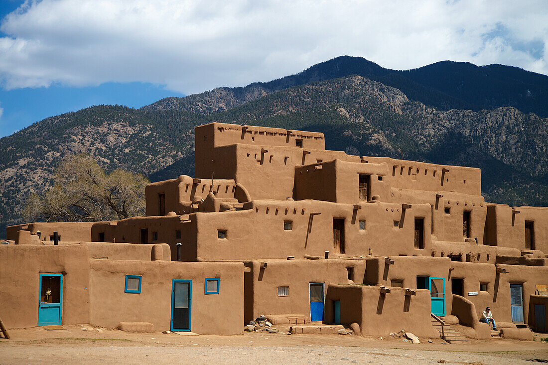 Ein Wohngebäude mit Bergen im Hintergrund; Taos Pueblo, New Mexico, Vereinigte Staaten von Amerika