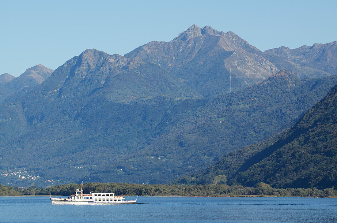 Ein Boot auf dem Lago Maggiore mit den Schweizer Alpen im Hintergrund; Locarno, Tessin, Schweiz