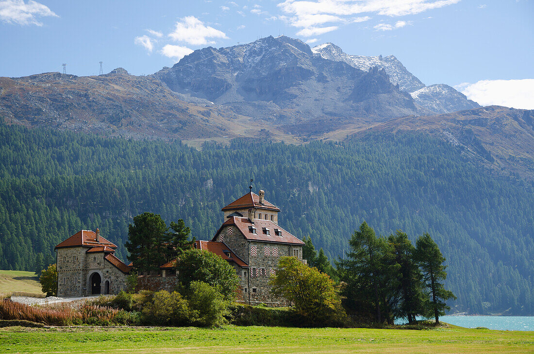 Castle Crap Da Sass On The Lake Front With Snow-Capped Mountain And Lake Silvaplana With Blue Sky And Clouds; St. Moritz, Grisons, Switzerland