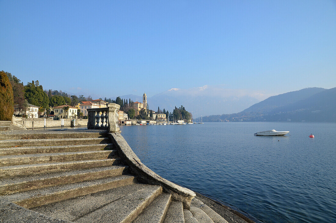 Stufen entlang der Wasserkante und Gebäude am Ufer des Comer Sees; Lombardei, Italien