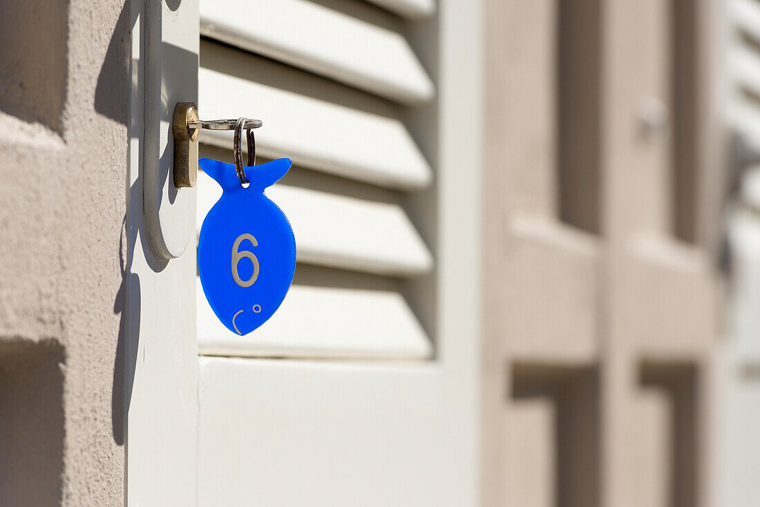 Ein blauer Schlüsselanhänger in Form eines Fisches mit einer Nummer sechs; Rimini, Emilia-Romagna, Italien