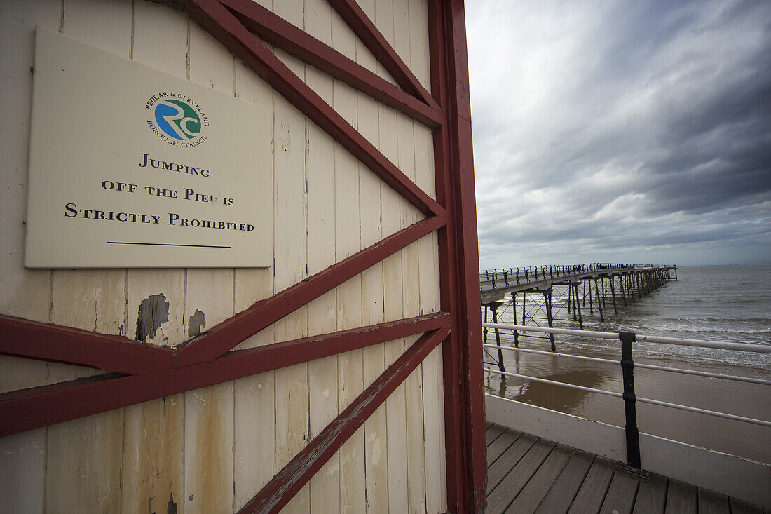 Sign On The Side Of A Building To Prohibit Jumping Off The Pier; Saltburn, North Yorkshire, England