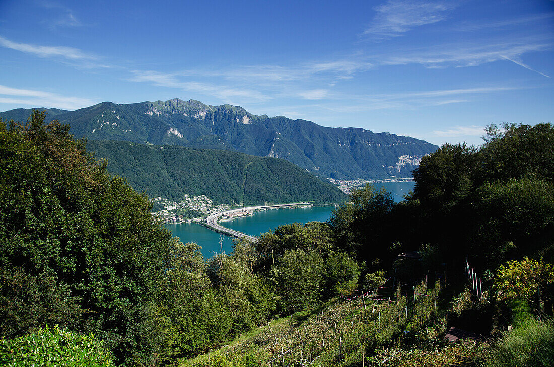 Eine Autobahn überquert einen Alpensee in den Schweizer Alpen; Lugano, Tessin, Schweiz