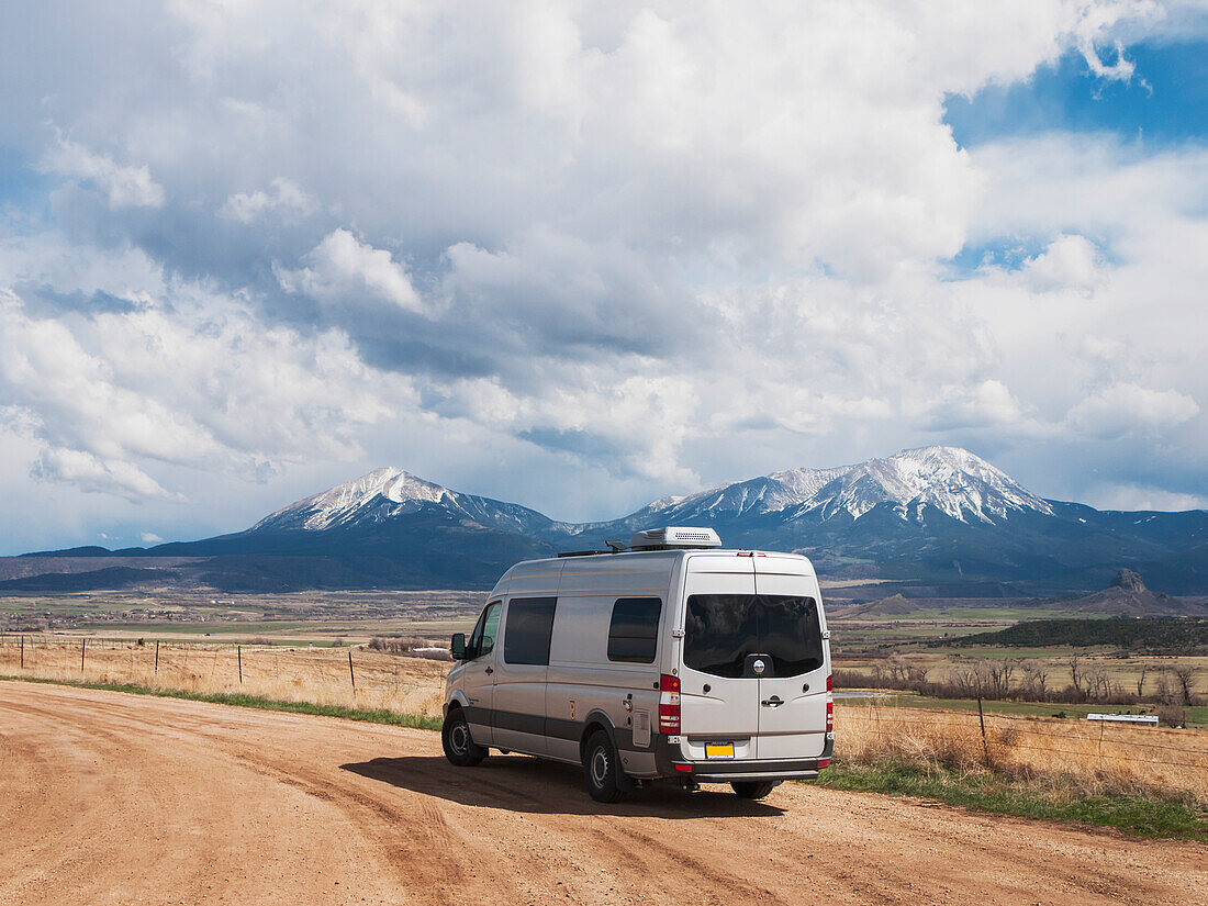 A Camper Parked On A Gravel Road Just East Of Walsenburg, Colorado With Snow Covered East And West Spanish Peaks In The Background; Walsenburg, Colorado, United States Of America