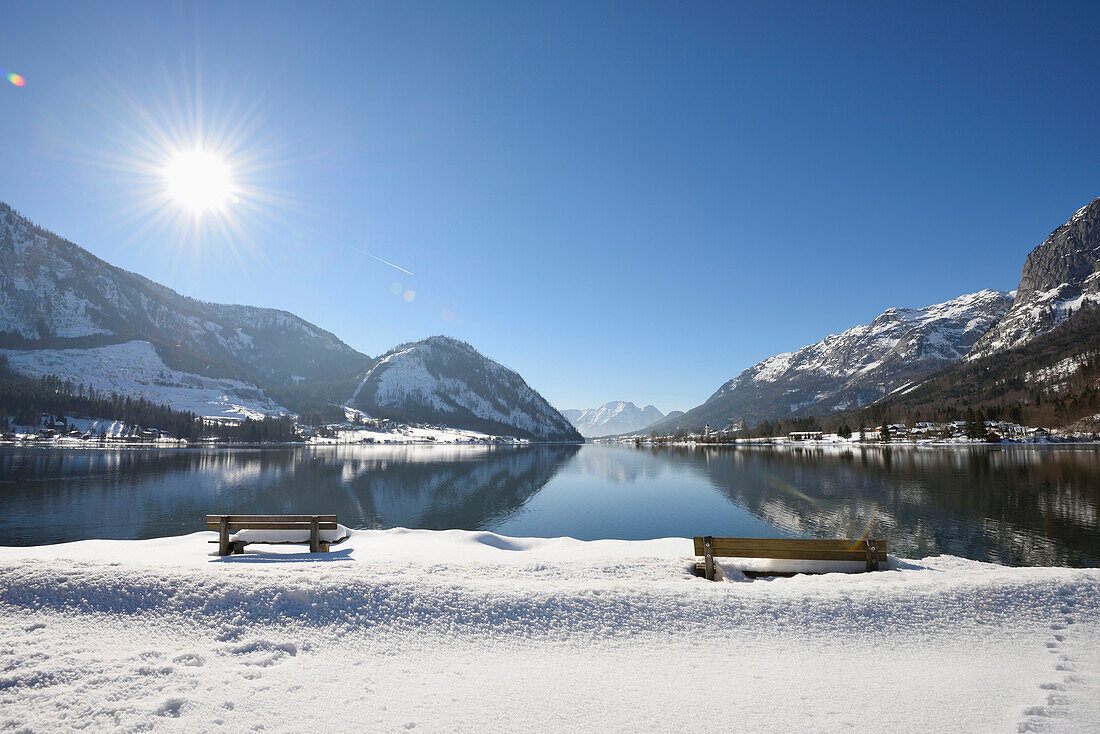 Landschaft mit Bänken im Schnee neben dem Grundlsee im Winter, Bezirk Liezen, Steiermark, Deutschland