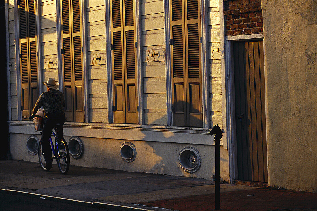 Man Riding Bicycle at Dusk, New Orleans, USA