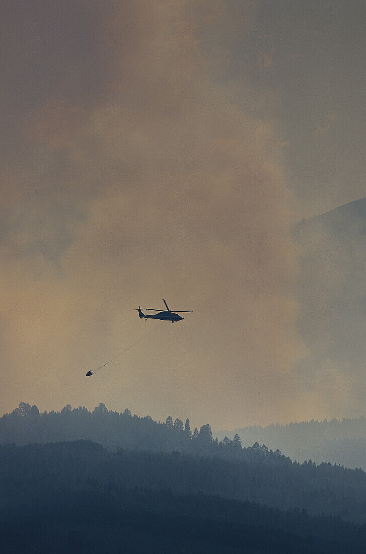 Rauch von Waldbrand mit Löschhubschrauber