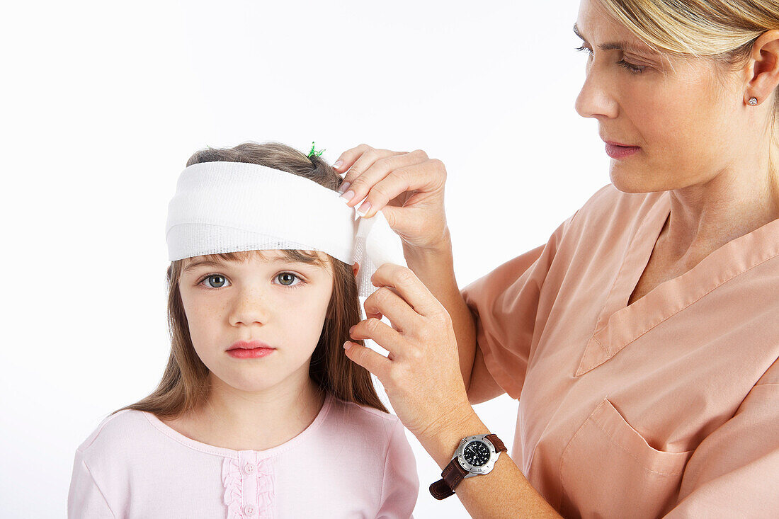 Nurse Wrapping Bandage Around Girl's Head