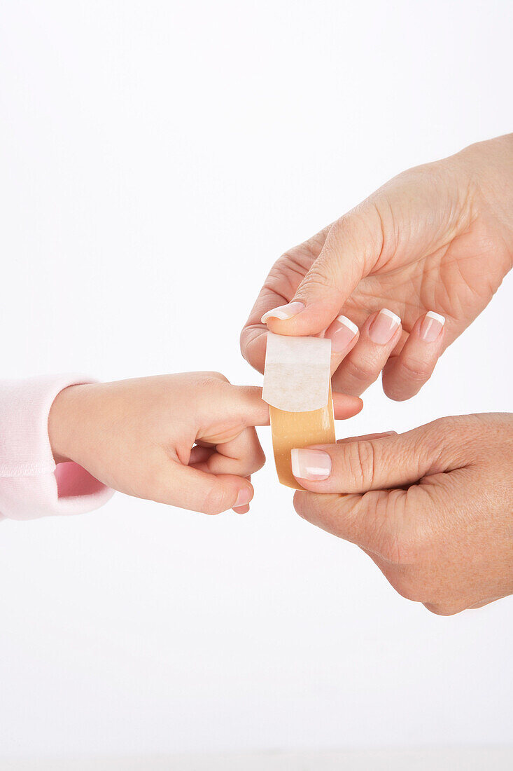 Mom Putting Bandaid on Daughter's Finger