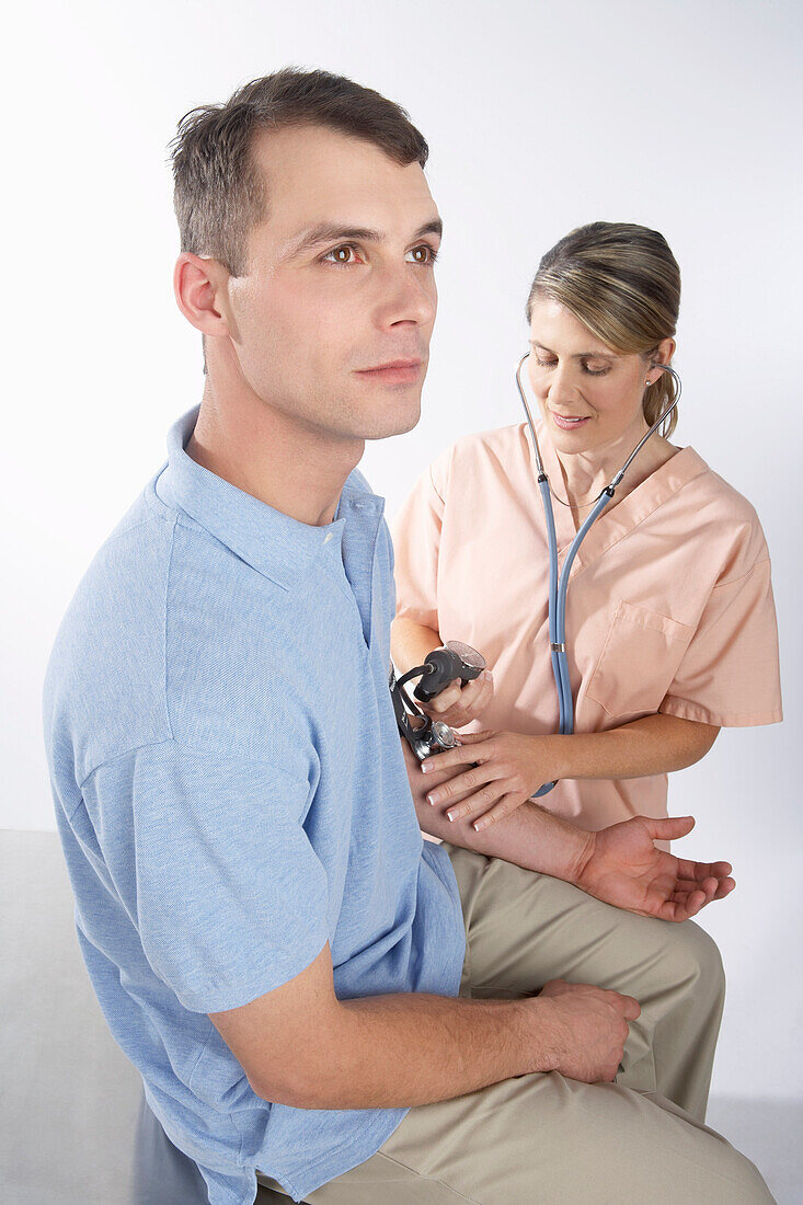 Krankenschwester prüft Blutdruck des Mannes