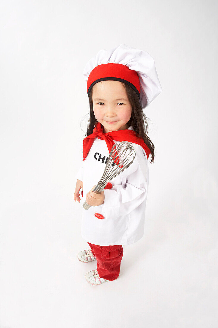 Little Girl Dressed Up as a Chef Holding a Whisk