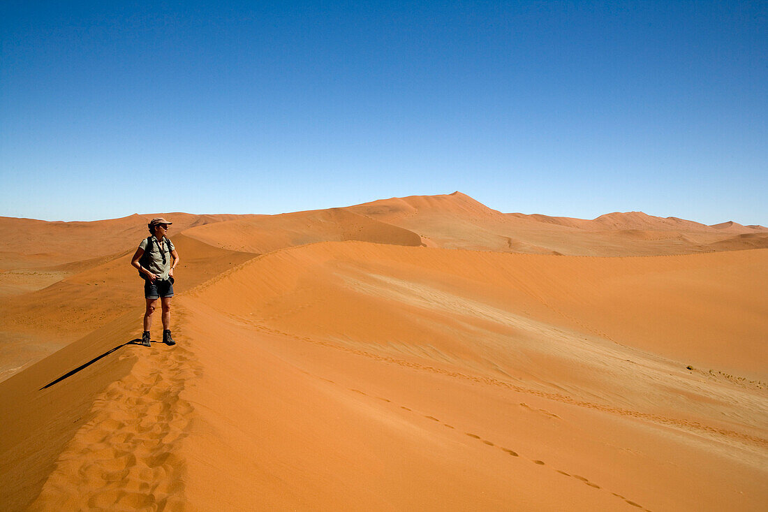 Frau auf Sanddüne stehend, Namib-Naukluft National Park, Namibia