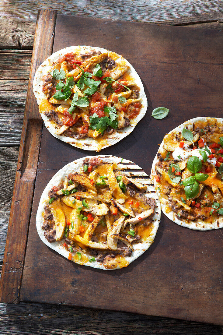 Grilled Mini Pizzas with Chicken, Avocado, Basil, Cilantro, Refried Beans, Hot Peppers and Salsa