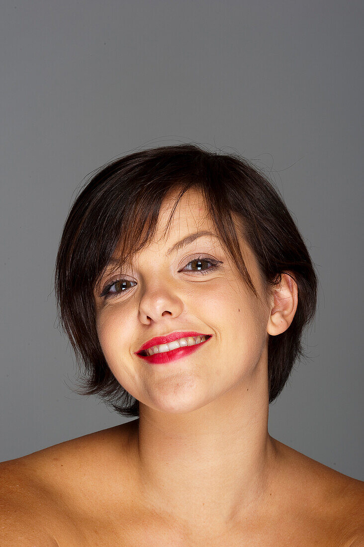 Kopf- und Schulterporträt einer mittelgroßen erwachsenen Frau mit grauem Hintergrund