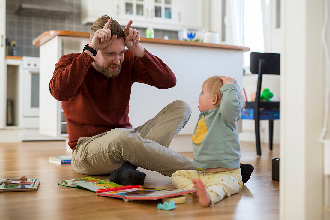 Vater und Kleinkind mit Down-Syndrom beim Spielen