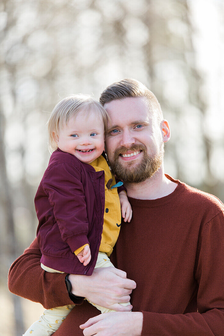 Portrait von Vater und lächelndem Baby mit Down-Syndrom