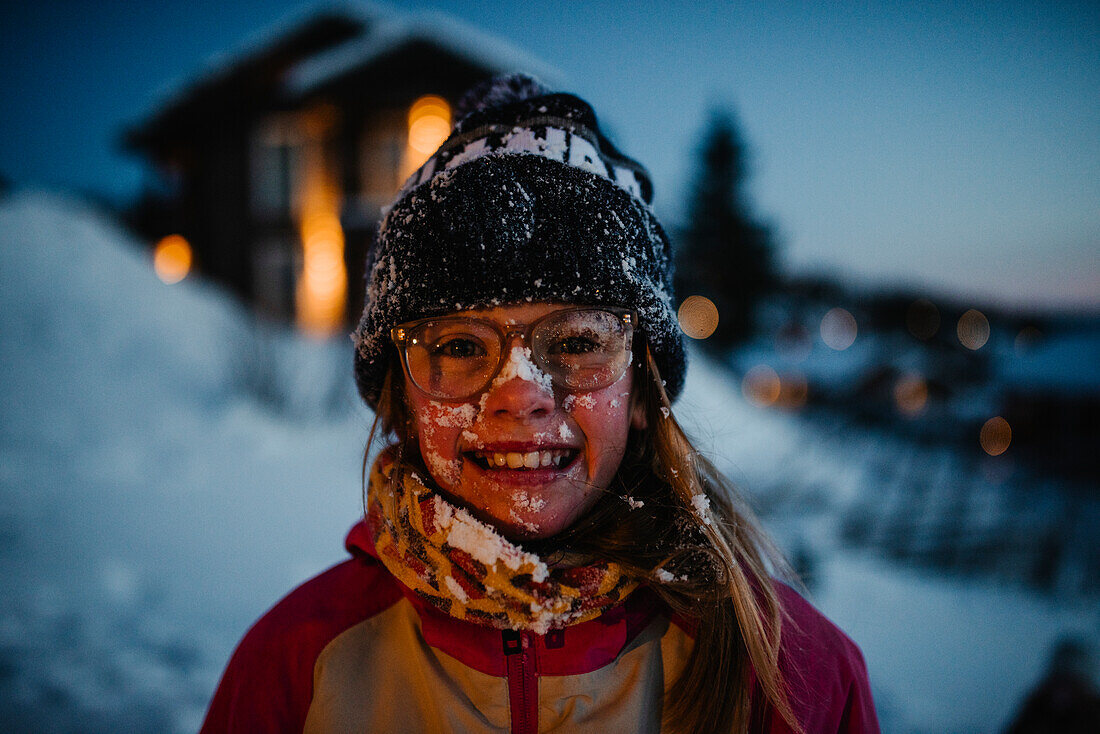 Happy girl covered in snow looking at camera