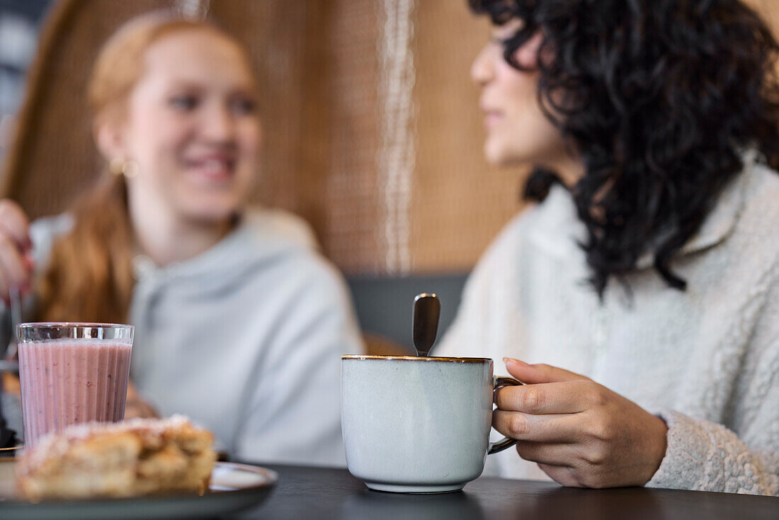 Women eating and drinking coffee in cafe