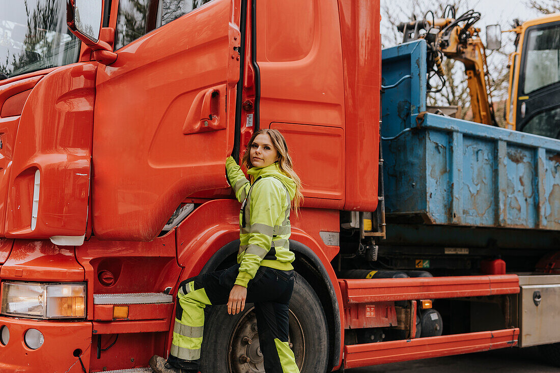 Portrait of female construction worker opening truck door
