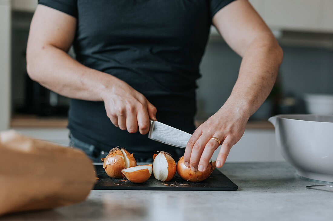 Man's hands cutting onions