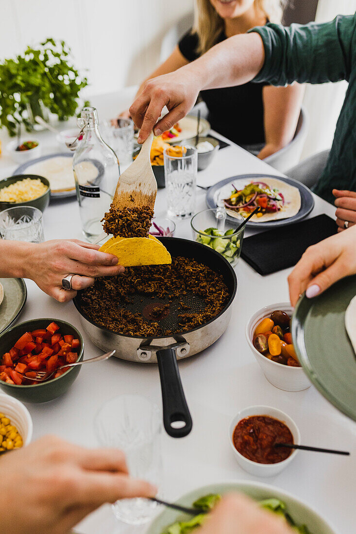 Group of friends eating tacos at home