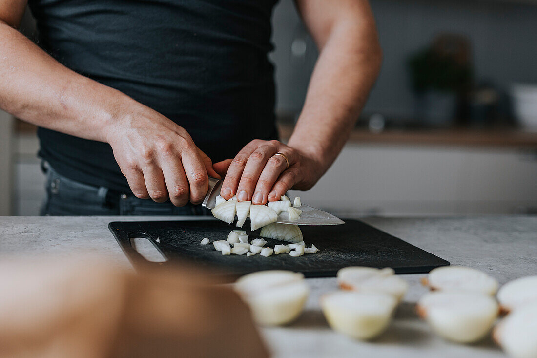 Man's hands chopping onions
