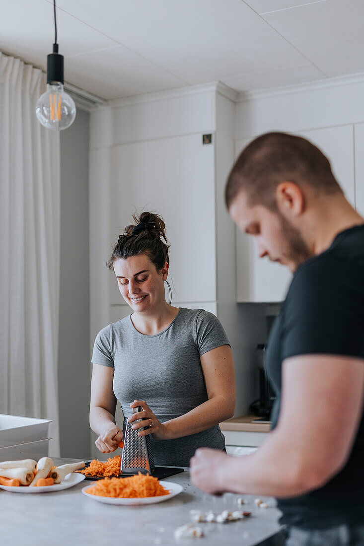 Couple in kitchen preparing food together