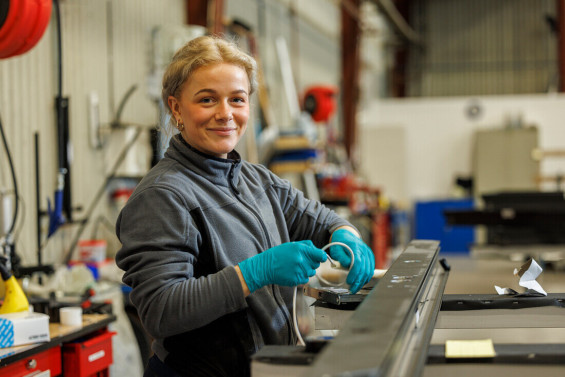 Young female industrial worker working in factory