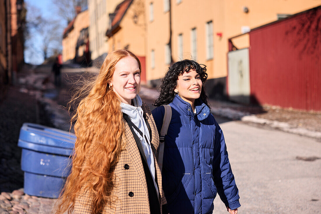 Female friends walking together ourdoors on walkway in city