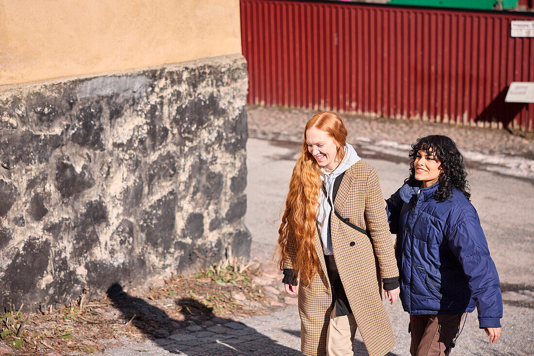 Female friends walking together ourdoors on walkway in city