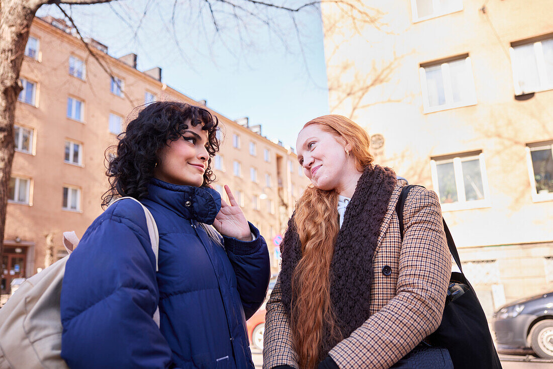 Female friends smiling and looking at each other