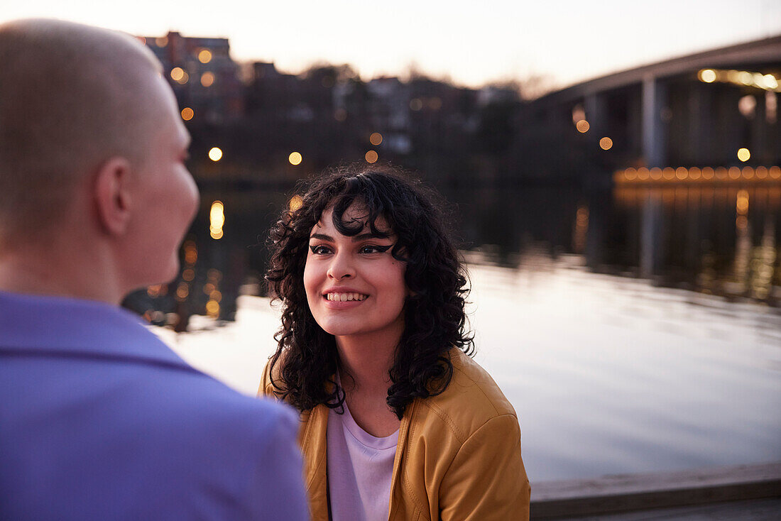 Young woman looking away, river in background