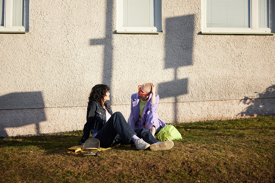 Lächelnde Freundinnen oder schwules Paar entspannen zusammen im Frühling