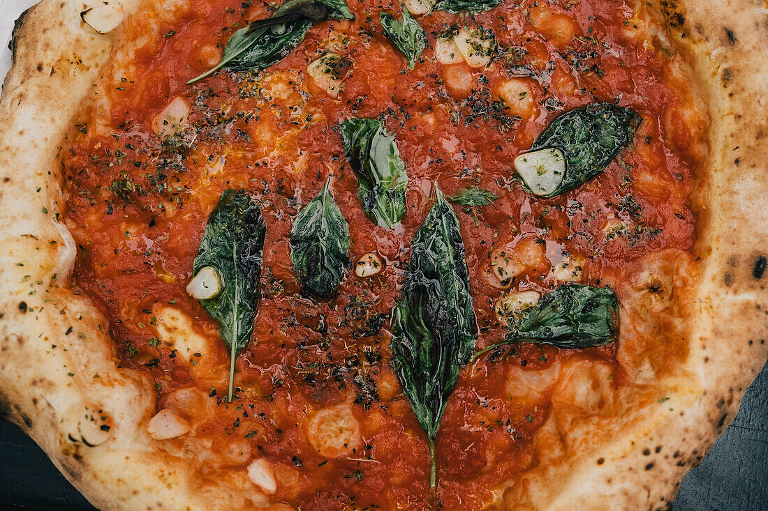 Pizza mit Tomatensauce und Basilikum
