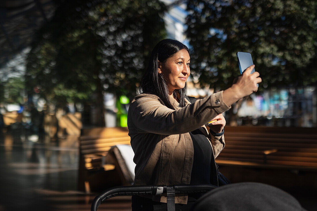 Blick auf lächelnde erwachsene Frau beim Selfie machen