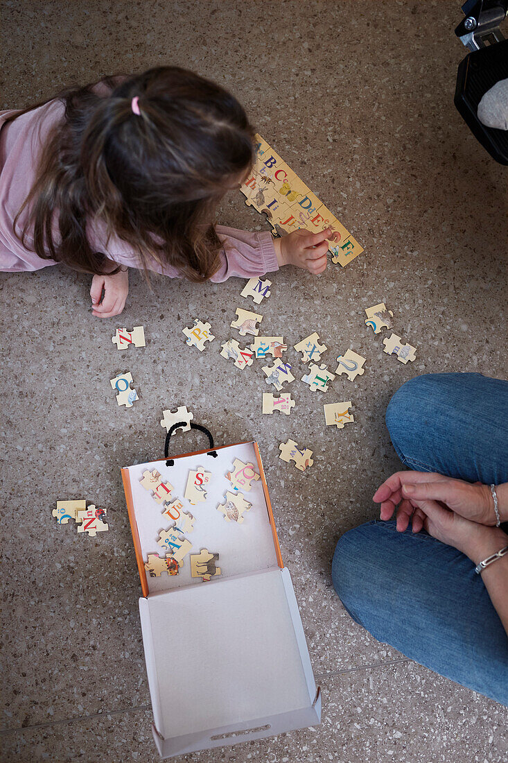 Girl lying on floor and doing jigsaw puzzles