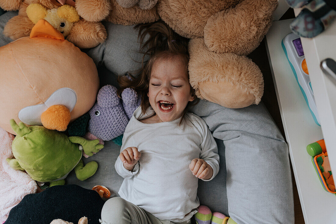 Glückliches behindertes Mädchen auf dem Bett liegend