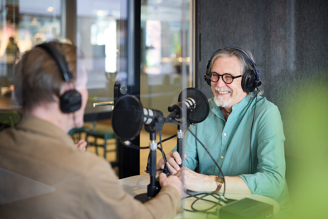 Männlicher Radiomoderator im Gespräch mit seinem Gast in einer Radiosendung oder einem Podcast