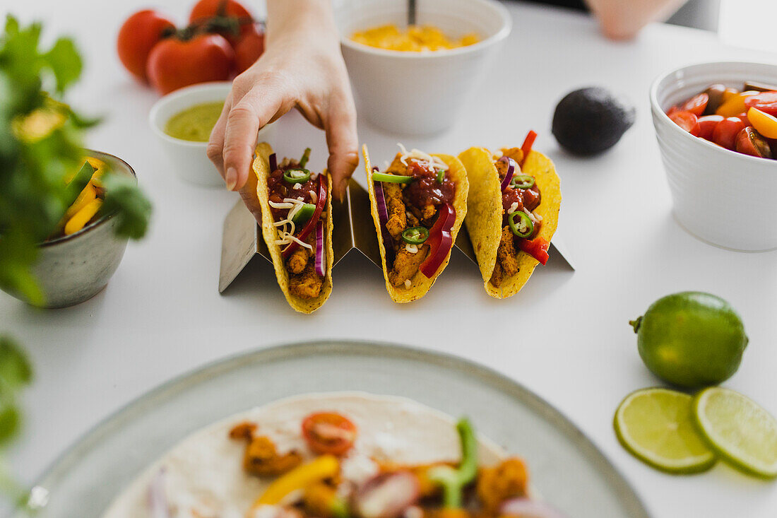 Person nimmt mexikanischen Taco vom Tablett