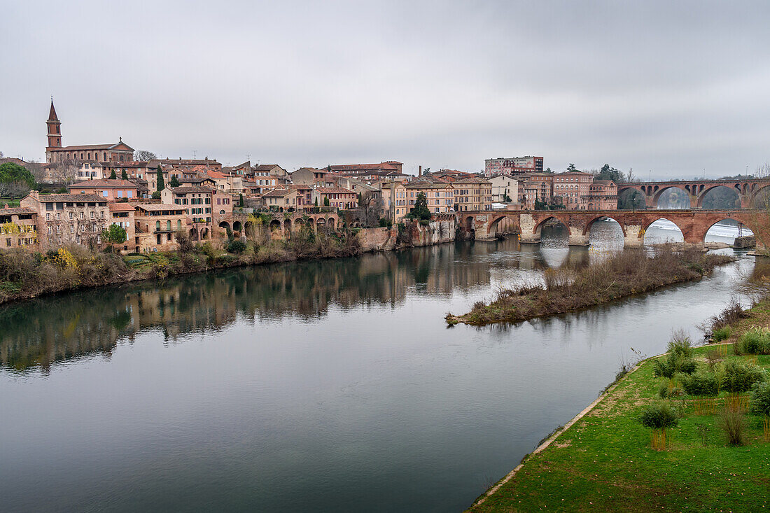 View of Albi, the city and historic buildings from the River Tarn, the Pont Vieux and an island in the stream. 