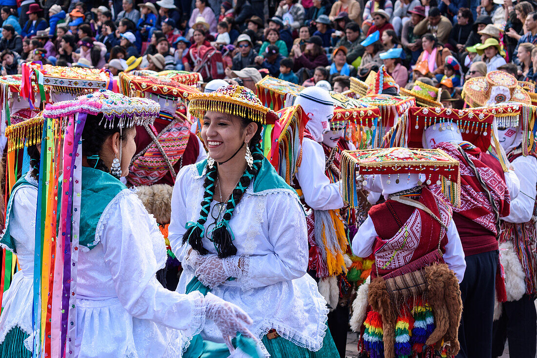 Cusco, ein kulturelles Fest, Menschen in traditionellen bunten Kostümen mit Masken und Hüten, bunte Luftschlangen.