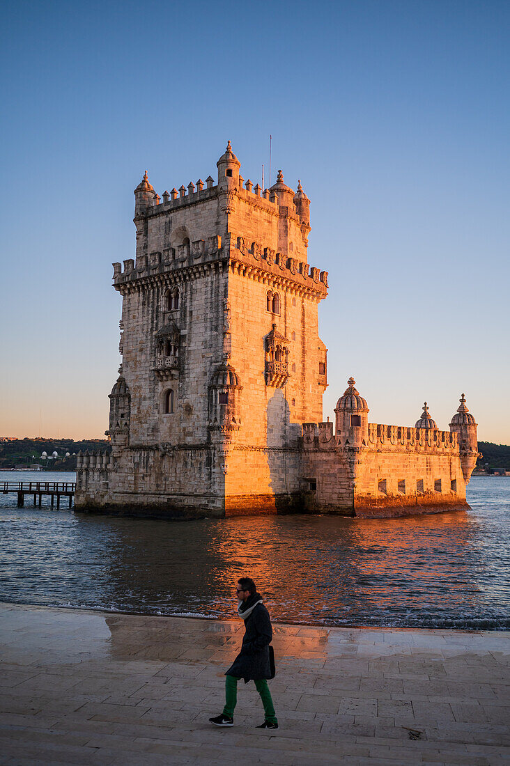 People enjoy a beautiful sunset from Belem Tower or Tower of St Vincent on the bank of the Tagus River, Lisbon, Portugal